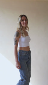video of a woman show what a white primrose crop tank looks like