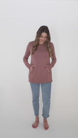 Barefoot woman with blond hair wears jeans and a Blondie Apparel Hillside Sweater in Mauve
