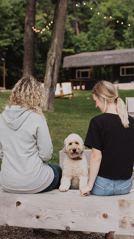 Blondie Apparel Founders Brodie and Michelle with Brodie's dog, Keeper on a wooden bench