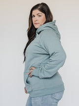 Woman with her hand on her hip while wearing the Blondie Classic Forest Hoodie in Trooper Green